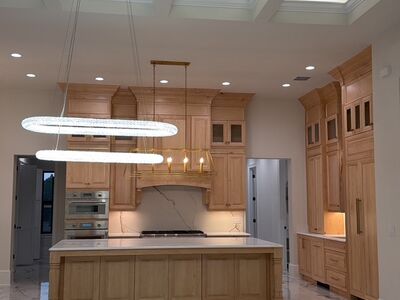 Large open kitchen area with wooden cabients and hanging lights