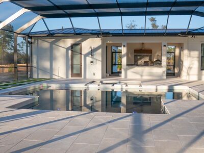 Square shaped pool in large screened in porch