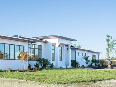 Front of property showing off large windows and plants