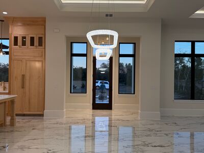 Large open space with marble floors and oval shaped lights hanging above the entrance